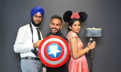Invités avec des accessoires de super-héros devant le photobooth